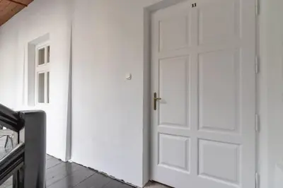 a white door in a white room with a wooden floor at Heart of the City Apartments Market Square Cracow by Noclegi Renters in Kraków