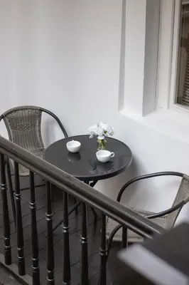 a small black table and chairs on a balcony at Heart of the City Apartments Market Square Cracow by Noclegi Renters in Kraków