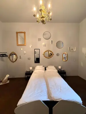 a large bed in a room with a chandelier at Two Paws Apartment in Kraków