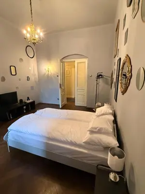 a bedroom with a large bed and a chandelier at Two Paws Apartment in Kraków