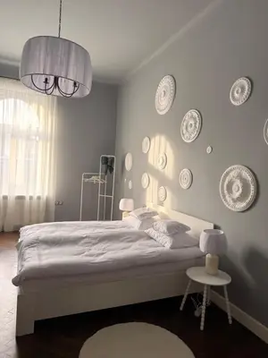 a bedroom with a bed with plates on the wall at Two Paws Apartment in Kraków