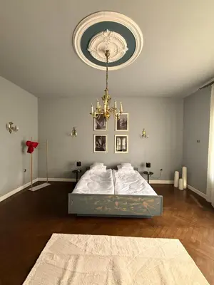 a bedroom with a bed and a chandelier at Two Paws Apartment in Kraków
