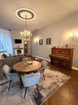 a living room with a table and a piano at Two Paws Apartment in Kraków