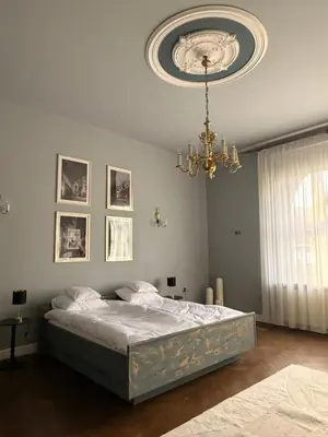 a bedroom with a bed and a chandelier at Two Paws Apartment in Kraków