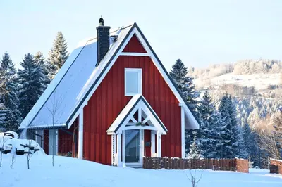 a red barn in the snow with snow covered trees at Hygge Beskid in Lachowice
