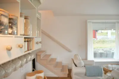 a living room with stairs and a chair and a window at Hygge Beskid in Lachowice