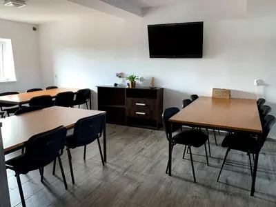 a conference room with tables and chairs and a flat screen tv at Kwatery Smroków in Smroków