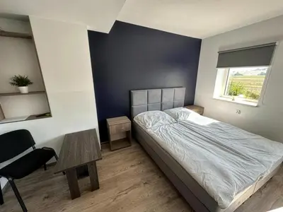 a bedroom with a bed and a chair and a window at Kwatery Smroków in Smroków