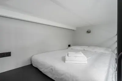 a white bed with two towels on top of it at Świętej Gertrudy Chic Apartment by BookingHost in Kraków