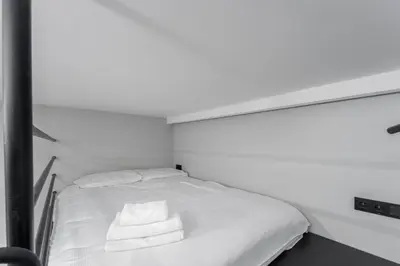 a white bed with two towels on top of it at Świętej Gertrudy Chic Apartment by BookingHost in Kraków