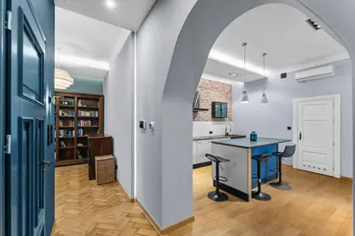an archway leads into a kitchen and dining room with a table at Świętej Gertrudy Chic Apartment by BookingHost in Kraków