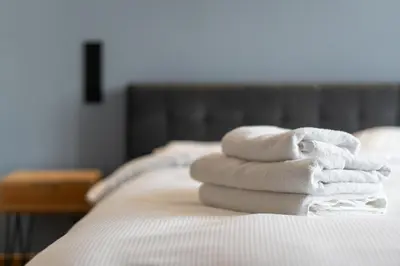 a pile of towels sitting on top of a bed at Świętej Gertrudy Chic Apartment by BookingHost in Kraków