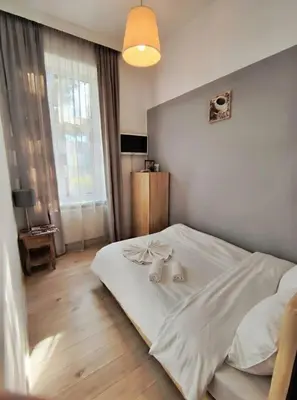 a bedroom with a white bed with two dolls on it at Apartment with elevator in the heart of Krakow in Kraków