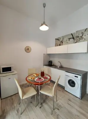 a kitchen with a table and chairs in a kitchen at Apartment with elevator in the heart of Krakow in Kraków
