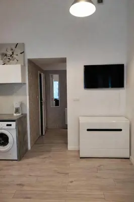 a living room with a washing machine and a tv on the wall at Apartment with elevator in the heart of Krakow in Kraków