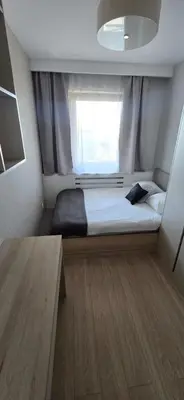 a small bedroom with a bed and a window at Blue Angel Apartment in Kraków