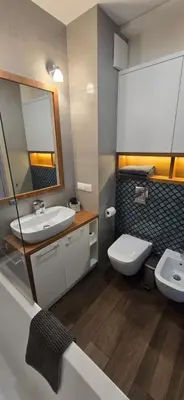 a bathroom with a sink and a toilet and a mirror at Blue Angel Apartment in Kraków