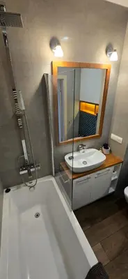 a bathroom with a bath tub and a sink at Blue Angel Apartment in Kraków