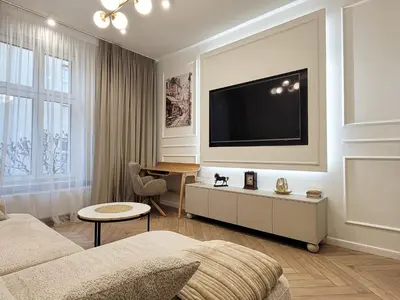 a living room with a couch and a tv on the wall at Apartament Krak Number One in Kraków