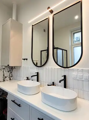 two sinks in a bathroom with two mirrors at Apartament Krak Number One in Kraków