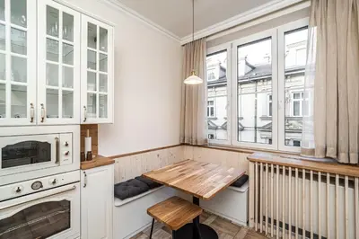 a kitchen with a table and some windows at RentPlanet - Apartament Sobieskiego in Kraków