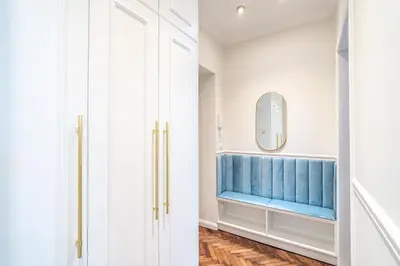 a bathroom with a blue bench and a mirror at RentPlanet - Apartament Sobieskiego in Kraków