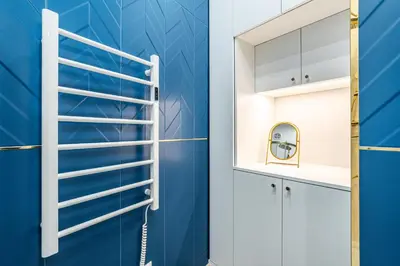 a blue bathroom with a ladder and a mirror at RentPlanet - Apartament Sobieskiego in Kraków