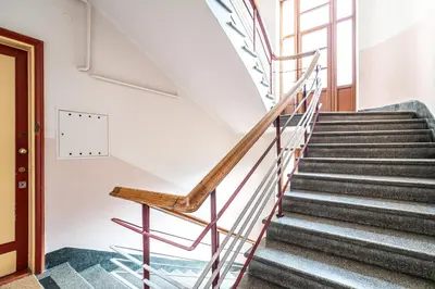 a set of stairs in a building with a wooden door at RentPlanet - Apartament Sobieskiego in Kraków