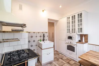 a kitchen with white cabinets and a stove top oven at RentPlanet - Apartament Sobieskiego in Kraków