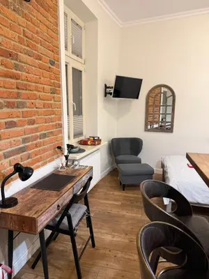 a room with a brick wall and a bed and a desk at KRK-SP Studio in Kraków