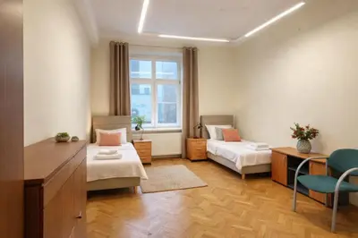 a room with two beds and a desk and a window at Urban Nest Apartments Długa 82 in Kraków