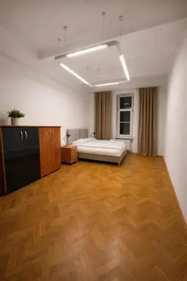 a large room with a bed and a wooden floor at Urban Nest Apartments Długa 82 in Kraków
