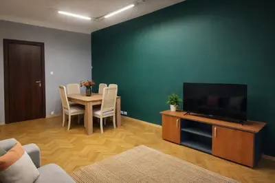 a living room with a table and a flat screen tv at Urban Nest Apartments Długa 82 in Kraków
