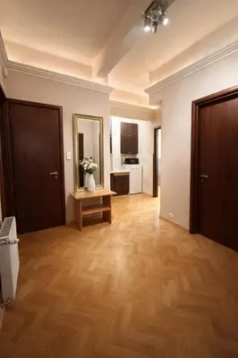 a large living room with wooden floors and a kitchen at Urban Nest Apartments Długa 82 in Kraków