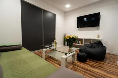 a living room with a glass table and a tv at Central Kazimierz Apartment in Kraków