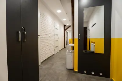 a hallway with a bathroom with yellow and black doors at Central Kazimierz Apartment in Kraków