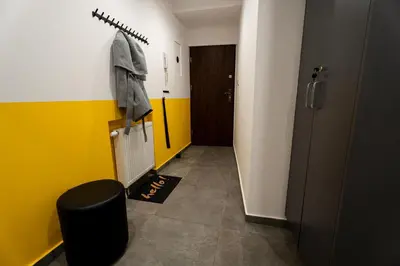 a bathroom with a hallway with a yellow and white wall at Central Kazimierz Apartment in Kraków
