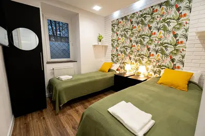 two beds in a room with a mural on the wall at Central Kazimierz Apartment in Kraków