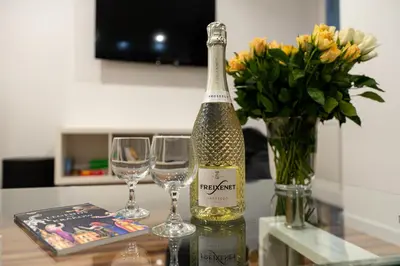 a bottle of champagne and two glasses on a table at Central Kazimierz Apartment in Kraków