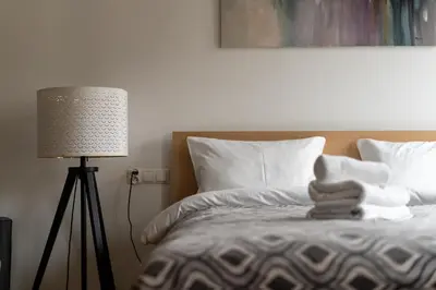 a bed with a pile of towels on it next to a lamp at Starowiślna 14 Downtown Studios by BookingHost in Kraków