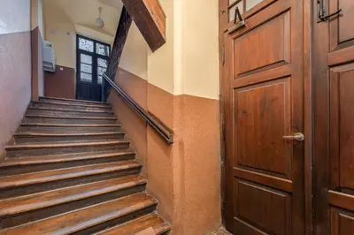 a hallway with a wooden door and stairs at Starowiślna 14 Downtown Studios by BookingHost in Kraków