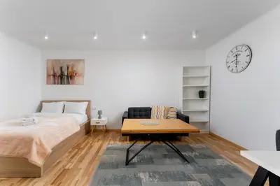 a bedroom with a bed and a table and a clock at Starowiślna 14 Downtown Studios by BookingHost in Kraków