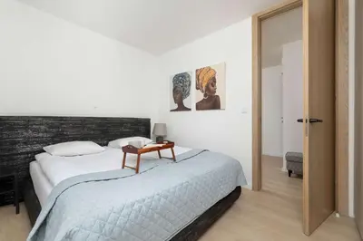 a bedroom with a bed with a table on it at Elegant Apartment Zbożowa in Kraków with Parking by Noclegi Renters in Kraków