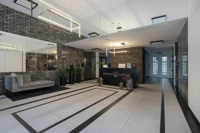 a lobby with a couch and a chair in a building at Elegant Apartment Zbożowa in Kraków with Parking by Noclegi Renters in Kraków