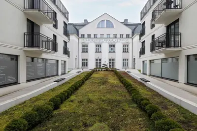an empty courtyard of a building with plants at Elegant Apartment Zbożowa in Kraków with Parking by Noclegi Renters in Kraków