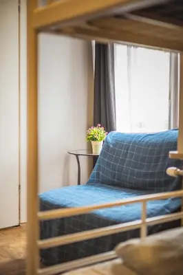 a bunk bed with a blue mattress and a window at 4Friends&4Couples in Kraków