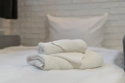 a pile of towels sitting on top of a bed at Traugutta Cozy Studio by BookingHost in Kraków