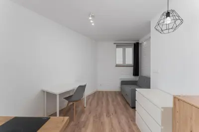 a kitchen and living room with a desk and a couch at Traugutta Cozy Studio by BookingHost in Kraków