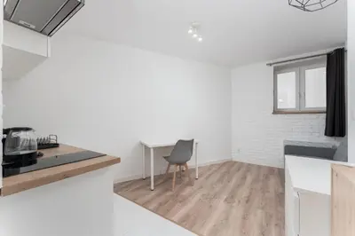 a kitchen with white walls and a chair in it at Traugutta Cozy Studio by BookingHost in Kraków