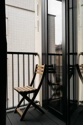 a wooden chair sitting on a balcony at Native Apartments Kościuszki 39I19 in Kraków